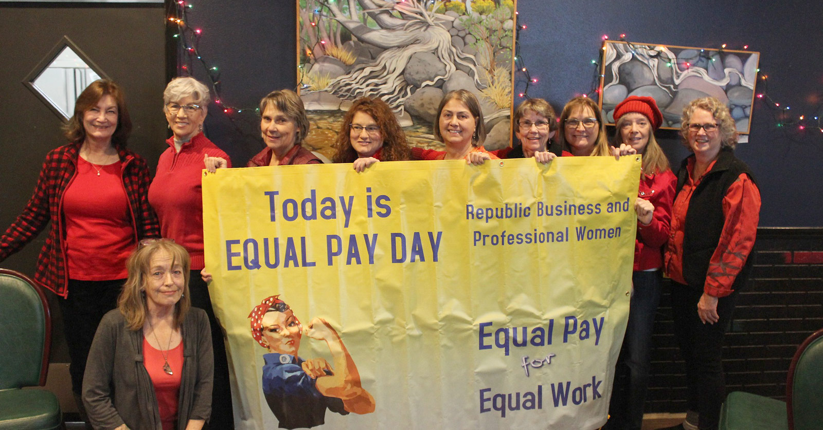 Women posing with a Today is Equal Pay Day sign